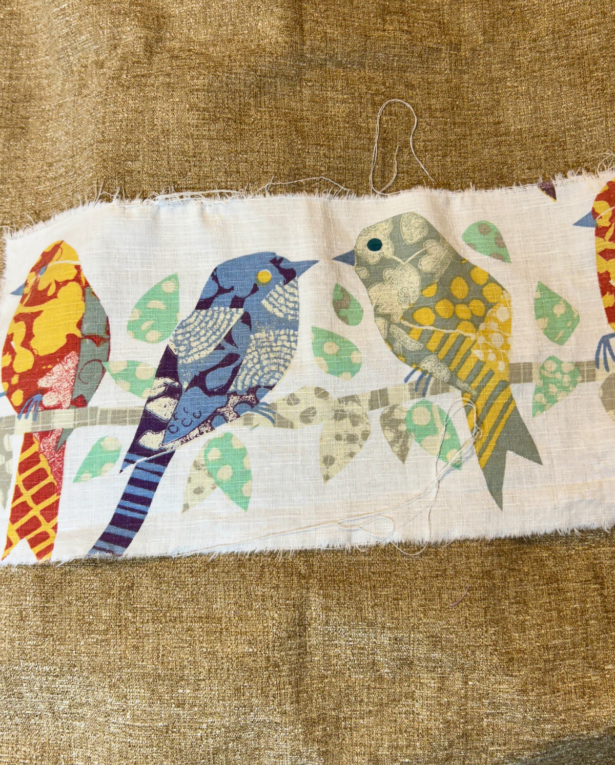 Fabric strip with colorful bird patterns on a brown background